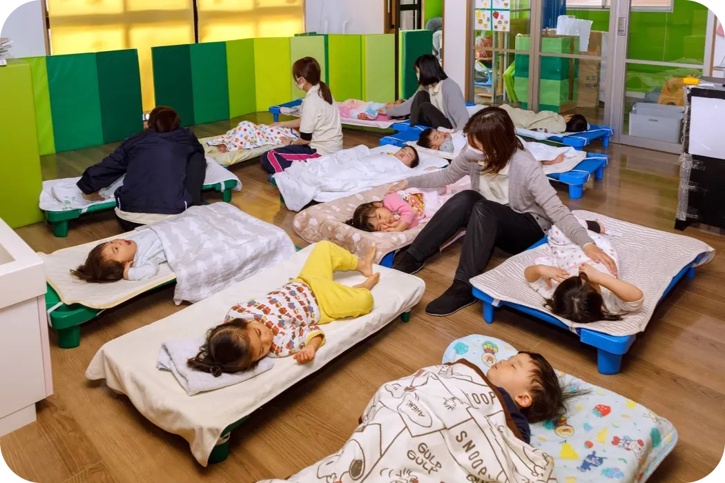 senju保育園の保育者が園児達に昼寝をさせている様子